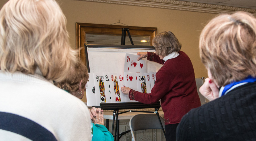 A woman using large playing cards on an easel.